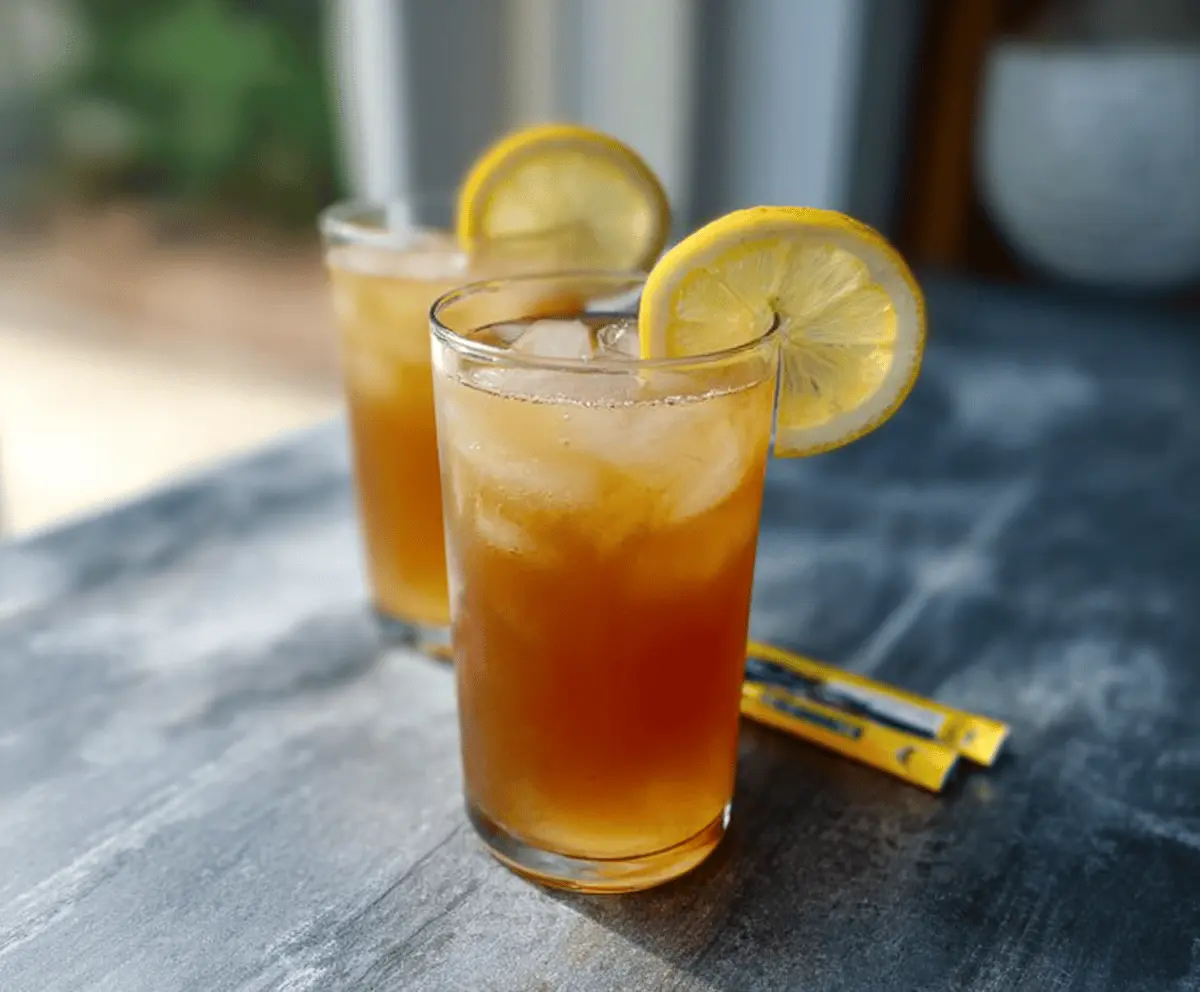 Refreshing Simple Arnold Palmer drink with lemon slices and ice in a glass, perfect for summer cooling