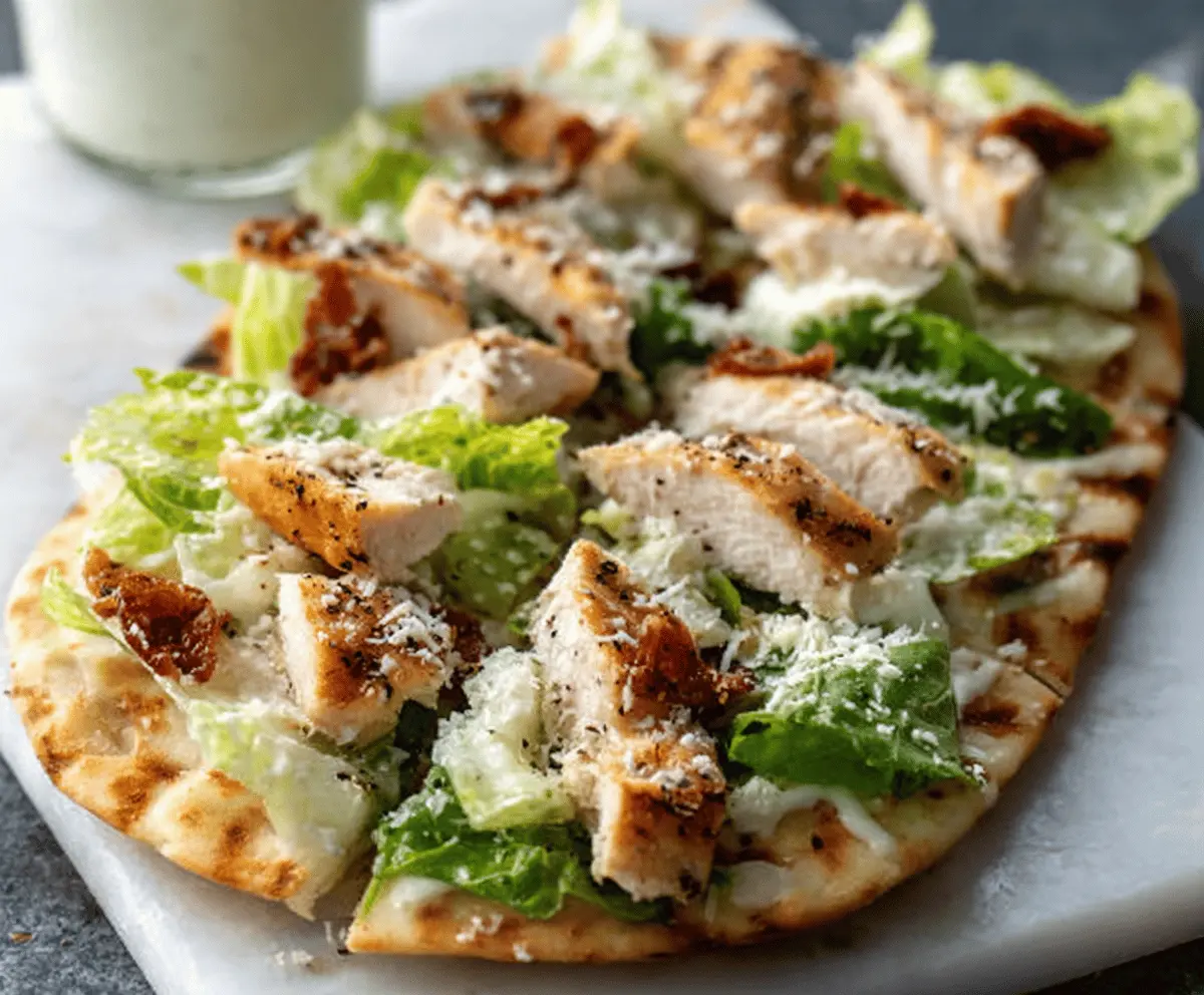 Delicious Chicken Caesar Flatbread topped with crispy chicken, romaine lettuce, and parmesan cheese
