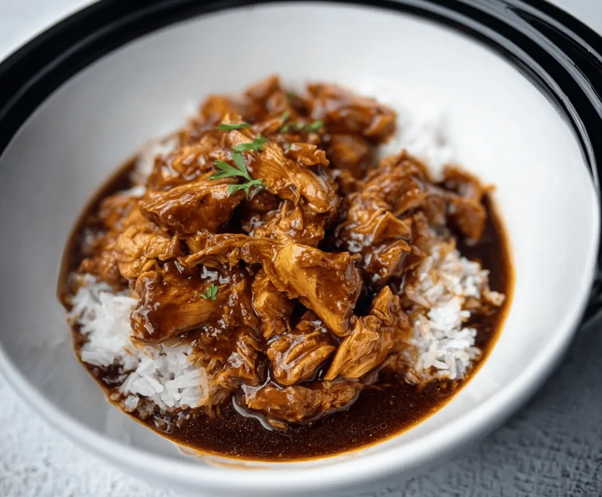 Delicious Crock Pot Bourbon Chicken served with side vegetables and rice.