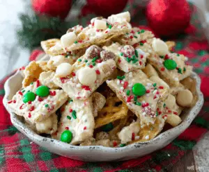 Delicious White Chocolate Christmas Crack treat with festive red and green sprinkles on a holiday-themed plate.